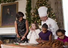First Lady Michelle Obama and White House Pastry Chef Bill Yosses laugh as young visitor tastes her decorated cookie during a holiday craft demonstration with the children of military personnel in the State Dining Room of the White House, Dec. 1, 2010. (Official White House Photo by Lawrence Jackson)