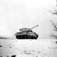 Photo: Painted white to blend with snow-covered terrain, an M-36 tank destroyer crosses a field. 

January 3, 1945