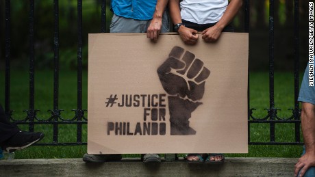 ST. PAUL, MN - JULY 07: A couple hold a sign protesting the killing of Philando Castile outside the Governor&#39;s Mansion on July 7, 2016 in St. Paul, Minnesota. Castile was shot and killed the previous night by a police officer in Falcon Heights, MN. (Photo by Stephen Maturen/Getty Images)