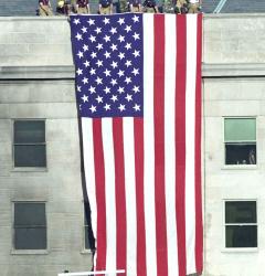 Following the terrorist plane attack on September 11, 2001, firefighters hoisted the American flag over the Pentagon.