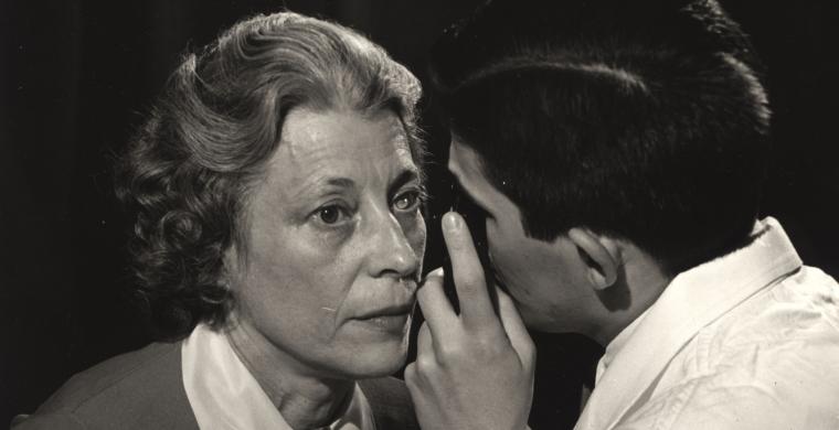 black and white photo of a doctor examining a female patient's eye
