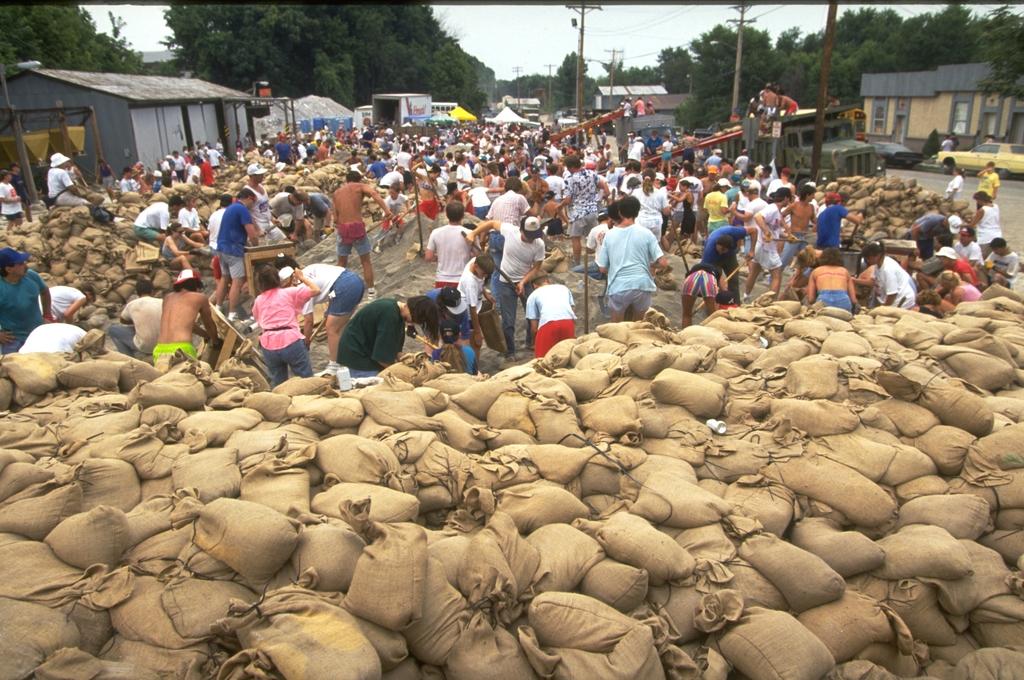 Midwest Floods, July 1993 -- Residents and volunteers work to fill sandbags in an effort to stop the flood from causing further damage. A total of 534 counties in nine states were declared for federal disaster aid. As a result of the floods, 168,340 people registered for federal assistance. Photo by Andrea Booher/FEMA Photo
