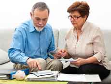 Una pareja de adultos mayores mirando documentos financieros