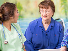 Un médico hablando con dos mujeres mayores