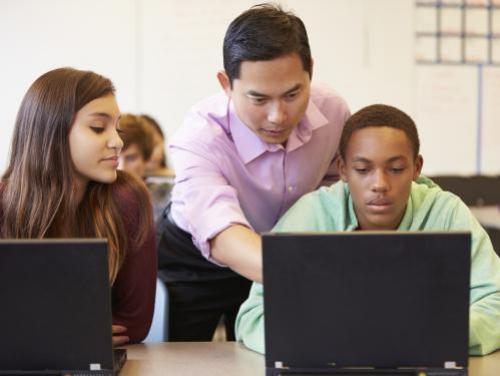 Educator and students at computers