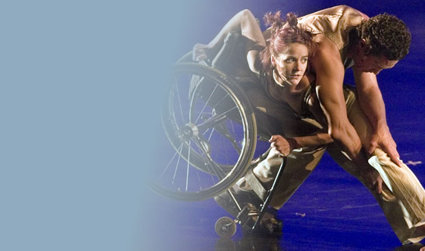 Man in a wheelchair dancing on stage with a female dancer.
