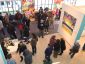 a crowd gathers in an exhibit space with graffiti-inspired artwork is on view