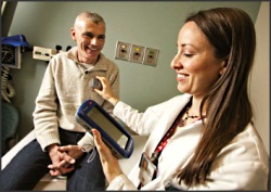 Photo of patient having their heart rate taken by a VA nurse.