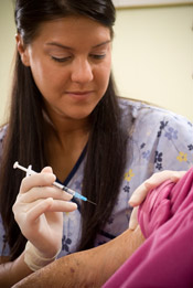 Female nurse giving someone a flu shot
