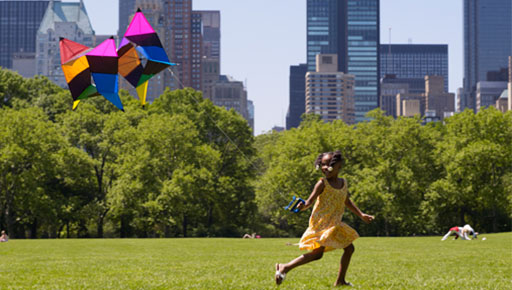 Girl running while flying kite