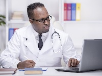 Photo of a doctor looking at a laptop computer
