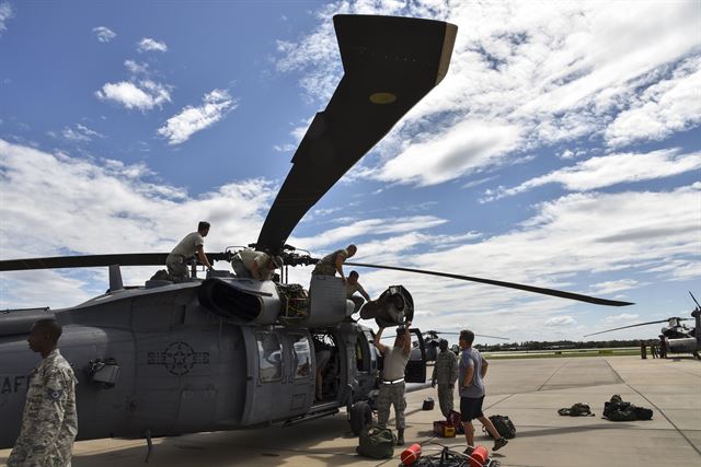 Airmen prepare a Pave Hawk helicopter for a rescue mission.