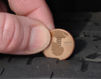 Photo of a penny being used to measure tire tread