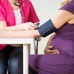 Stock image of a pregnant woman having her blood pressure taken