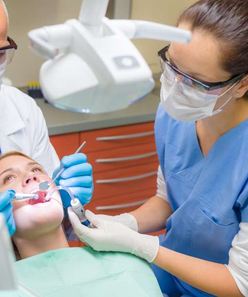 A Dental Assistant helps a dentist with a patient. 