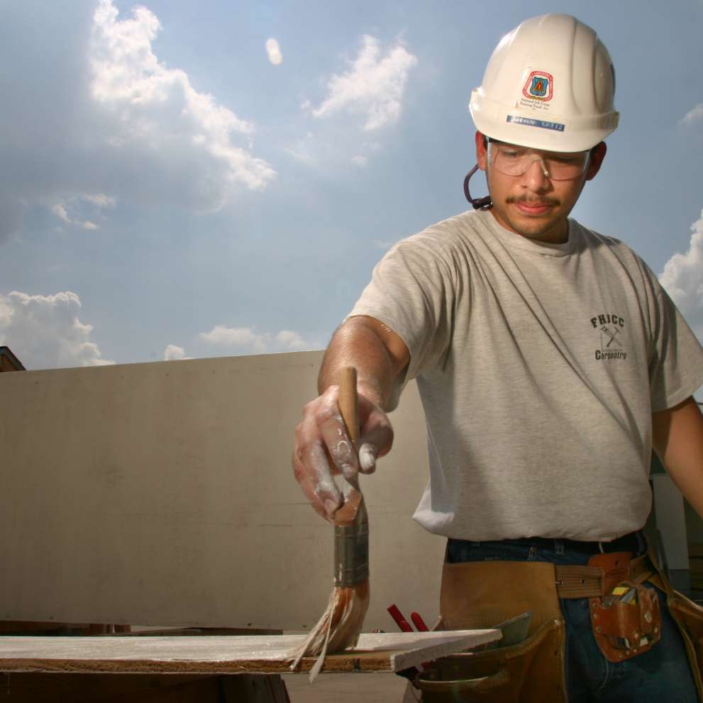 A construction worker mixes concrete.