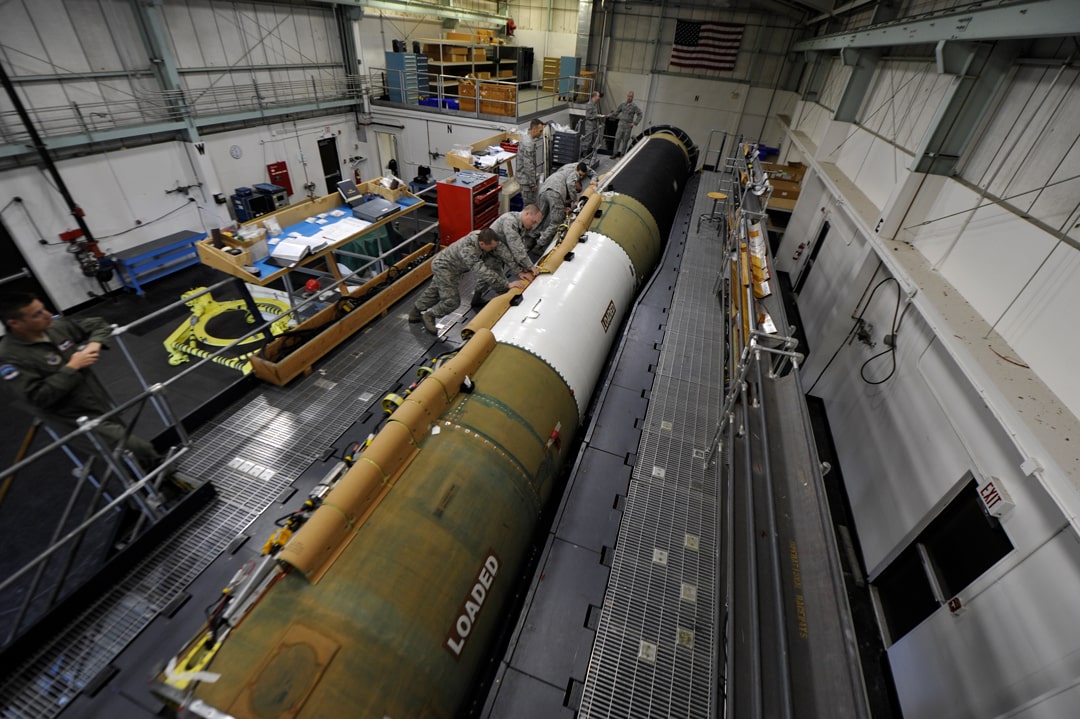 A LGM-30G Minuteman III being worked on by a crew of technicians.