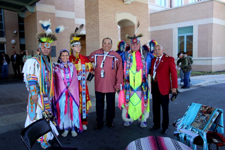 (At center) Master of ceremony, Gregorio Kishketon, and Abel Flores, co-event coordinator, take a group photo with members of the Lipan Apache Tribe of Texas before the start of a special event held in observance of National Native American Heritage Month, which took place at the VA outpatient clinic in Harlingen, Texas, on November 16, 2018. (U.S. Department of Veterans Affairs photo by Luis H. Loza Gutierrez)