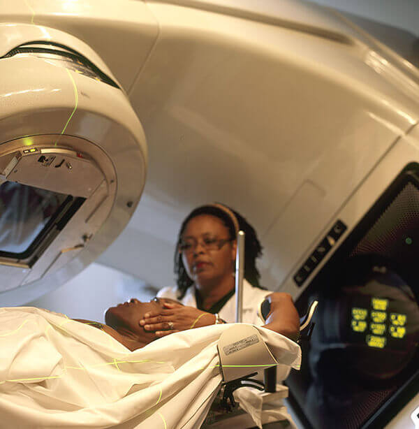 Un doctor preparando a un paciente para recibir un tratamiento de radioterapia