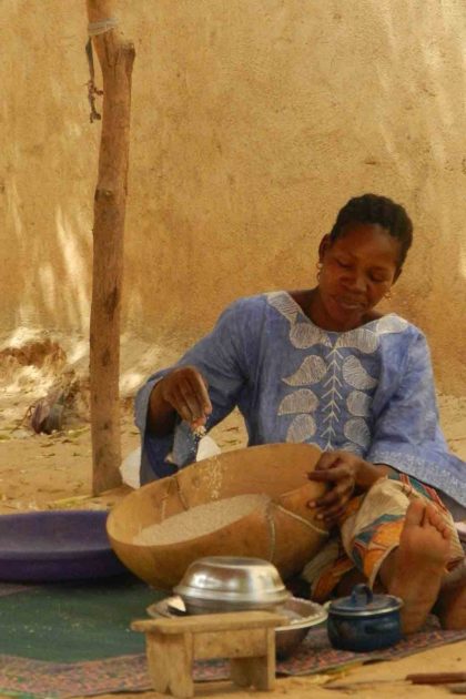 Mymouna Sidibe, co-president of a local women's food co-op, prepares millet to be transformed into cous cous.