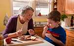 picture of an older woman and a young boy eating apples