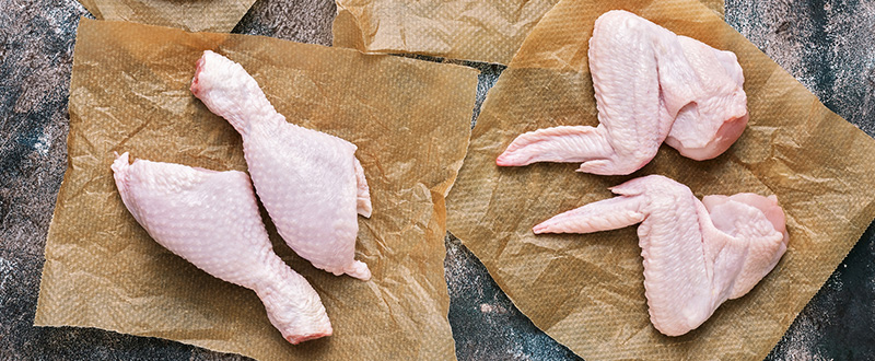Photo of raw chicken meat fillets, wings, thigh and legs.