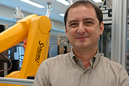 Anton Simeonov, Ph.D., and a high-throughput screening robot.