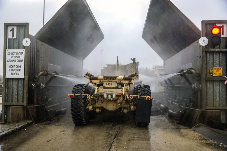 A large military vehicle gets sprayed down.