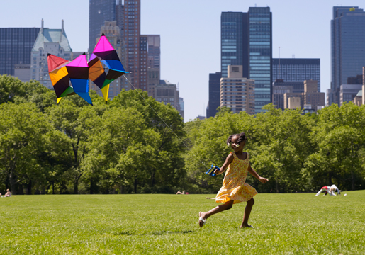 Girl running while flying kite
