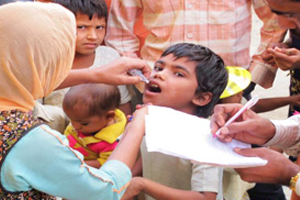 a young Indian boy receiving his oral polio vaccine from a trained eradication team vaccinator.
