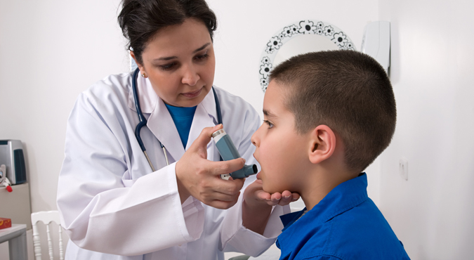a doctor helping a young boy with his inhaler