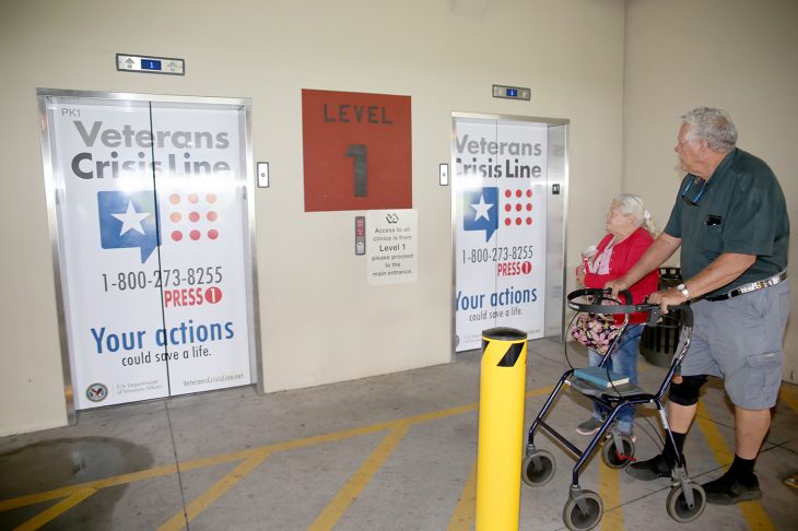 Navy Veteran Richard W. Noyes and his wife Mary notice the newly decorated elevator doors with the Veterans Crisis Line logo and number as they make their way back to their vehicle after visiting the VA Health Care Center at Harlingen, Texas, on September 11, 2018. (U.S. Department of Veterans Affairs photo by Luis H. Loza Gutierrez).