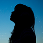 Silhouette of a girl against blue evening sky
