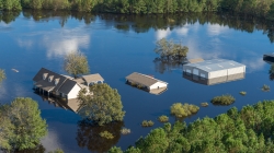 Bladen County, NC., September 18, 2018 -- An aerial photo of a house and nearby buildings in a wooded area heavily flooded from Hurricane Florence. (Photo posted on fema.gov.)