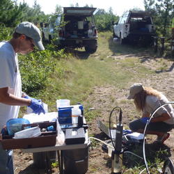 USGS scientists collecting a water sample from a well at the USGS Bemidji Research Site
