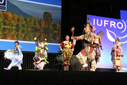 Five people, dressed in their ethnic attire, performing a dance routine on stage.