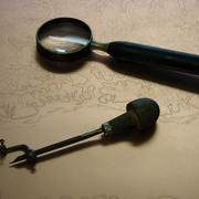 Tools of the trade for a US Geological Survey engraver- the burin and the hand lens, resting on a contours engraving.