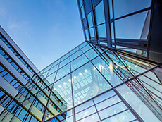 Upward angled image of a glass office building.