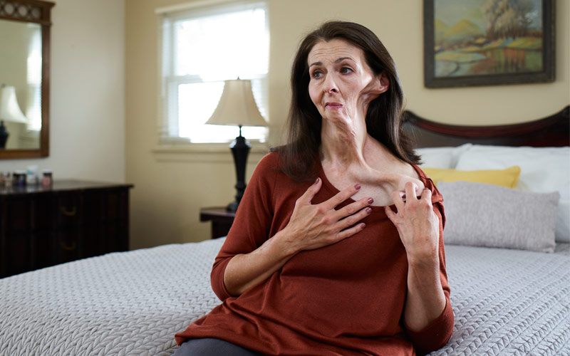 Christine, a Tips From Former Smokers Campaign Participant, sits on her bed in her bedroom.