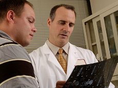 A male doctor talks with a male patient.
