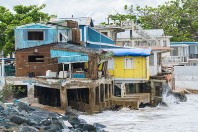 Brightly colored home is battered by winds and waves