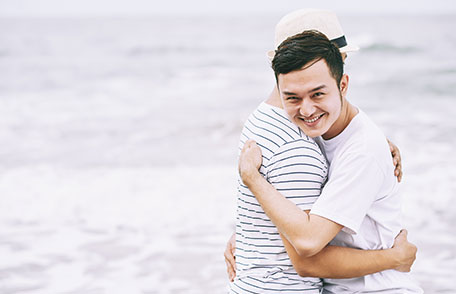 Two men hugging on the beach