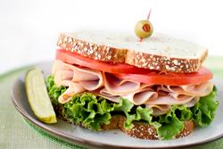 Sandwich with turkey, lettuce, and tomato.
