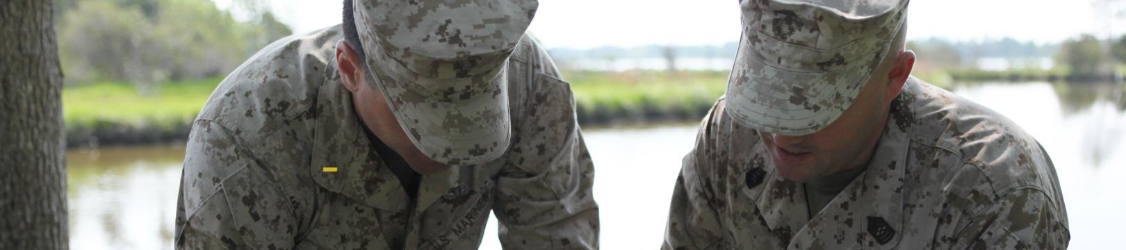 Two Marines perform an activity as part of the Marine Corps Combat Service Support Schools