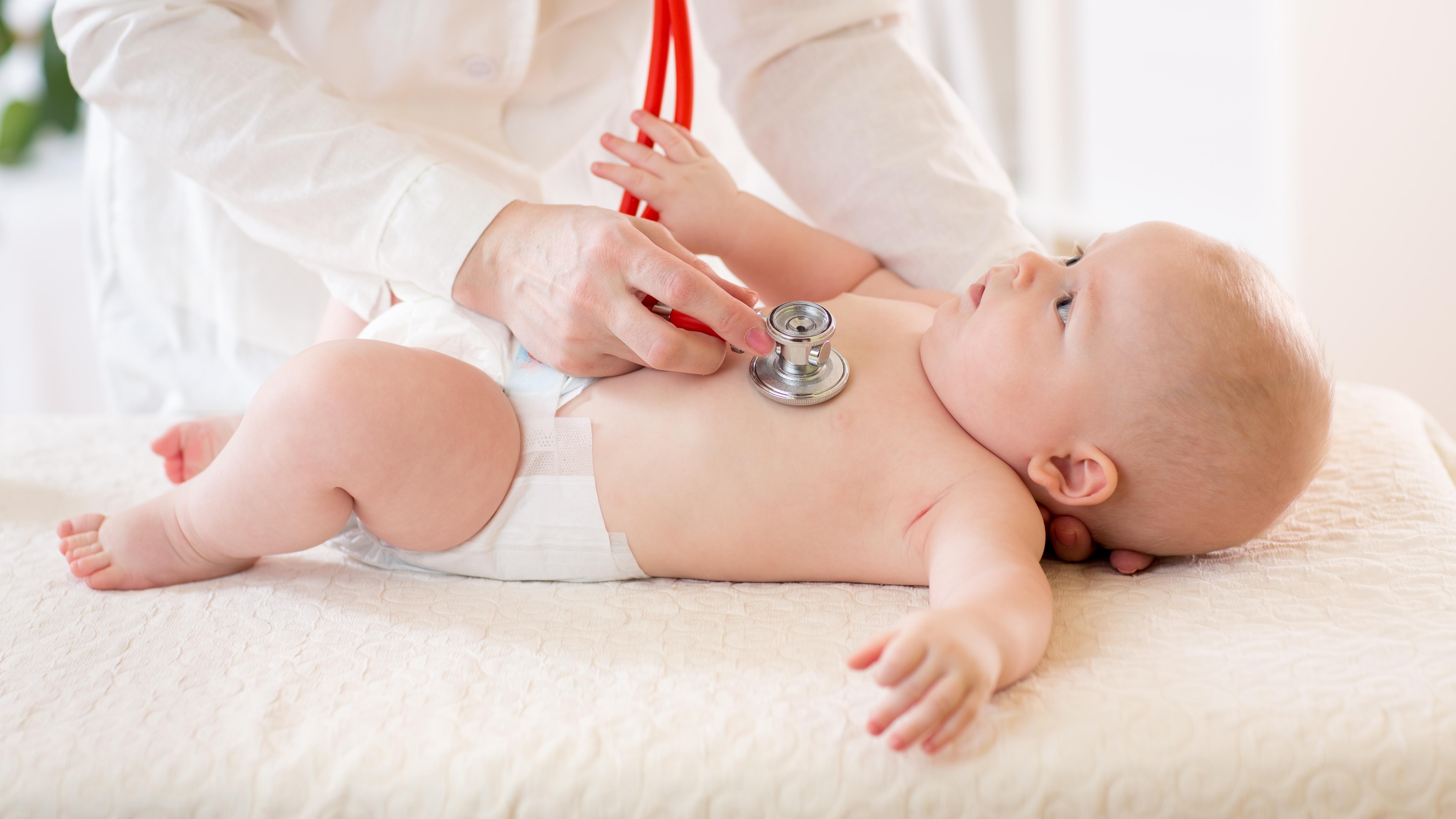 baby being examined by a doctor with stethoscope 