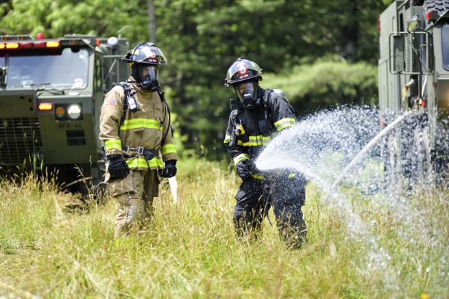 North Carolina Army and Air National Guardsmen extinguish a simulated crash fire during exercise Operation Vigilant Catamount in Dupont State Forest, Hendersonville, N.C., June 8, 2017. Army National Guard photo by Staff Sgt. David McLean