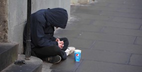 Homeless individual sitting on city street