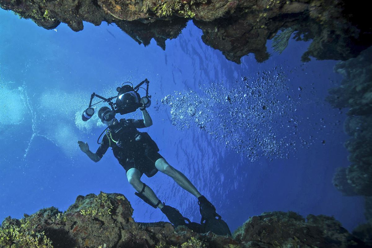 A sailor trains underwater with a camera.