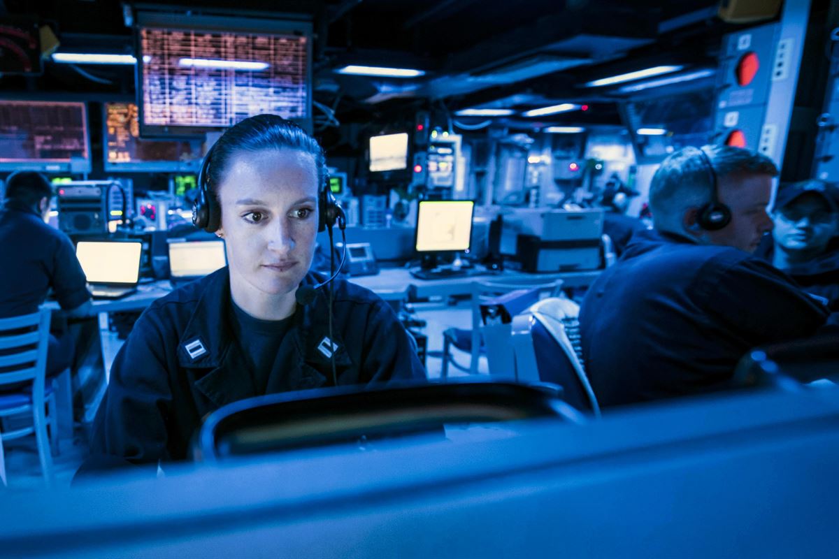 A sailor looks at the regional air and surface picture in a ship's command center.