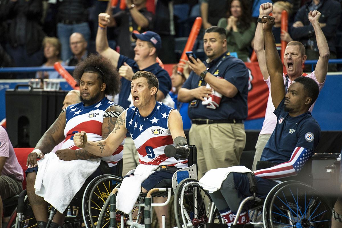 Wheelchair athletes cheer as their basketball team wins.